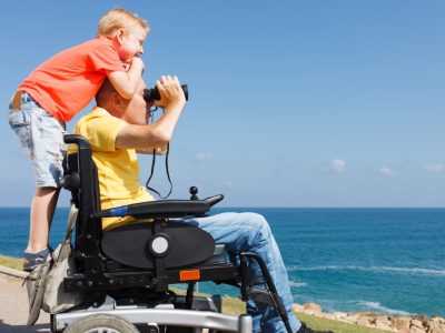 Vater im Rollstul mit Sohn und Fernglas